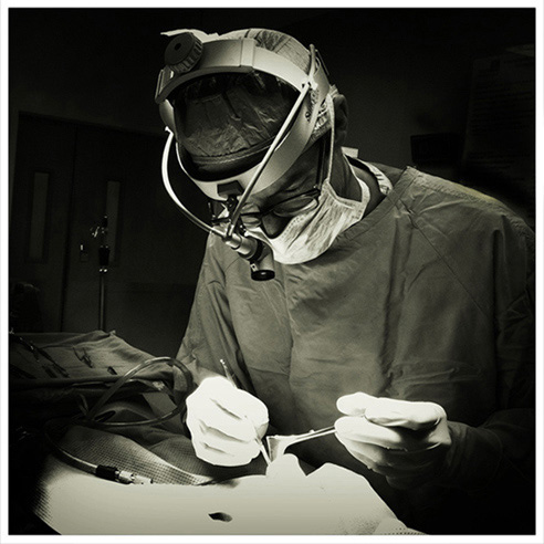 Thomas Lamperti, MD black and white photograph showing him performing rhinoplasty surgery.